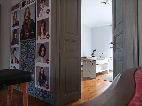 Interior room with celebrity photo collage on wall, open doorway leading to bathroom with sink visible beyond